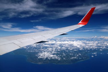 Punta Cana, Dominik Cumhuriyeti üzerinde uçaktan havadan görünümü. Bulutların üzerinde uçuyor. Atlantik Okyanusu üzerinde uçan bir uçağın kanadı.