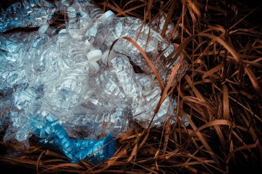 Gree üzerinde maden suyu ve şişe kapakları ezilmiş plastik şişeler