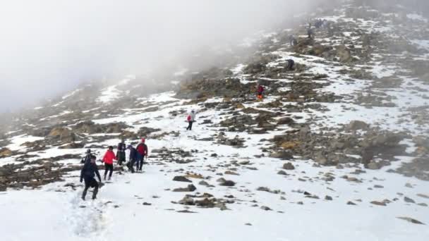 一群登山者在冬天从山上下山。多云 — 图库视频影像