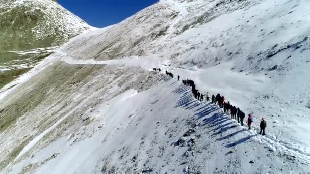 从后面的鸟瞰图。一群登山者在冬天爬山. — 图库视频影像