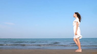 yalnız Kadın beyaz elbise li plaj boyunca yürüyüş