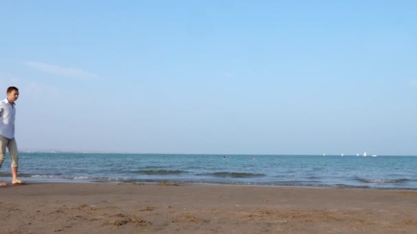 일몰 해변에서 걷는 커플 로맨틱 포옹. 해안 근처에서 손을 잡고 — 비디오