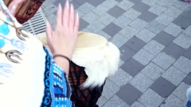 sokakta yavaş çekimde djembe jembe davul çalan kadın ellerin yakın çekim