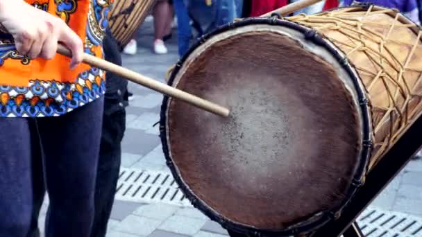 Man beats a huge cow drum with a big drumstick in slow motion. Summer evening — Stock Video