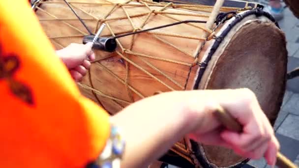 Afrykański bęben djembe gra na ulicy pałeczkami perkusyjnymi. Letni dzień. Zamknij się. — Wideo stockowe