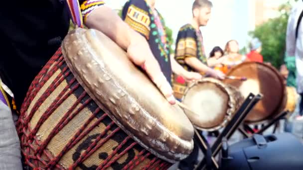 Close-up van de handen spelen op Afrikaanse djembe drums op een zonnige zomeravond. — Stockvideo