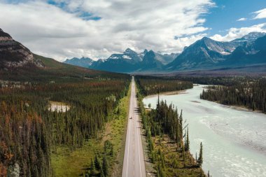 Aerial view of vehicles on scenic Icefields Parkway highway between Banff and Jasper National Parks during summer in Alberta, Canada.