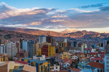 Illimani Dağı ve Güney Amerika, Bolivya 'da günbatımında yerleşim binaları dahil La Paz şehir manzarası.