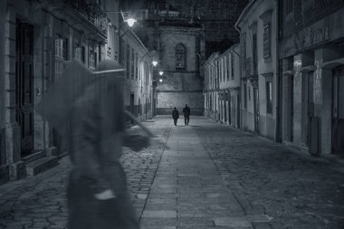 Bir ortaçağ şehir gece ön planda geçirerek gizemli bir uğursuz figür ile eski Avrupa sokaktan