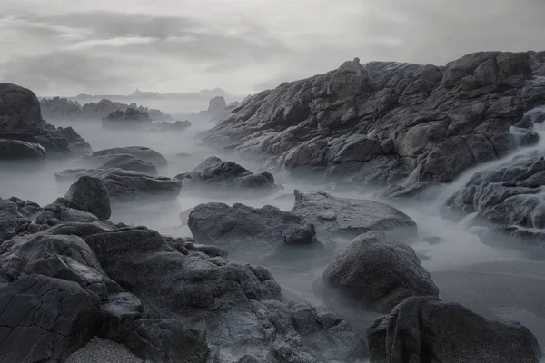 夕暮れ時に干潮時にポルトガルの北の岩のビーチ 長時間露光 — ストック写真