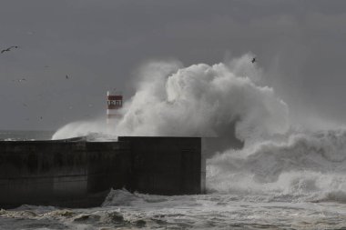 Büyük deniz dalga sıçrama. Douro nehir ağzı eski Güney granit iskele ve karanlık, fırtınalı ve üzücü bir gün ulusumuza yol gösteriyor.