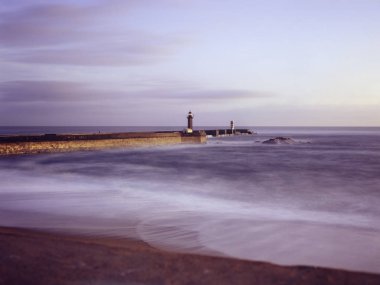 Foz beach eski ve yeni iskeleler ve işaretleri Douro Nehri ağzından günbatımında görmek. Porto, Portekiz. Uzun pozlama. Analog. 120 slayt film.