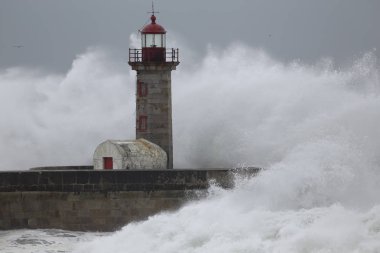 Eski deniz feneri ve granit iskele üzerinde büyük fırtınalı dalgalar