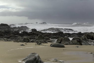 Büyük fırtınalı kırma dalgalar halinde Kuzey Portekiz boş kayalık plaj.