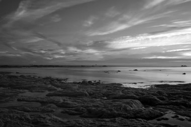 Uzun pozlama deniz manzarası. Düşük gelgit sırasında Kuzey Portekiz kıyısında kayalık plaj. Geç akşam ışığı. 