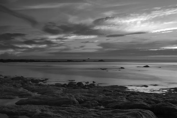 Larga exposición desde una playa de mar rocoso por la noche —  Fotos de Stock