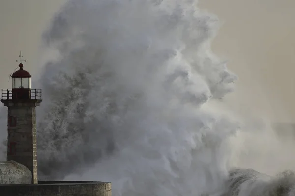 Wave schizza sul faro al tramonto — Foto Stock