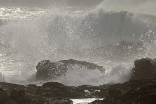 Onde di rottura dettagliate contro le rocce — Foto Stock