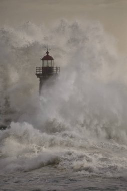 gün batımında deniz fenerini kaplayan tormy dalga sıçraması