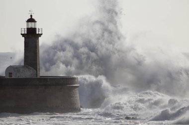 Eski deniz feneri üzerinde yumuşak arkadan aydınlatmalı dalgalar