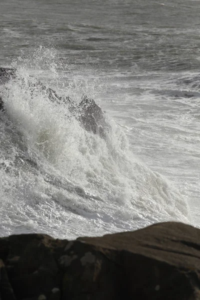 Big stormy waves breaking over rocks