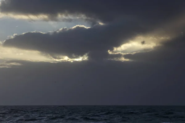 Céu escuro do mar nublado com raios de luz — Fotografia de Stock