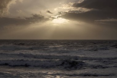 Işık ışınları ile denizde günbatımı