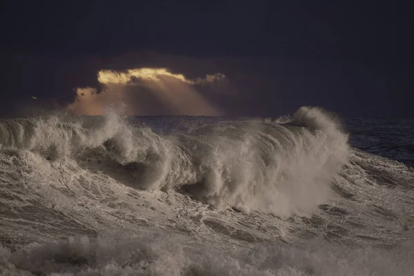 Viharos hullámok ellen sötét ég naplementekor — Stock Fotó