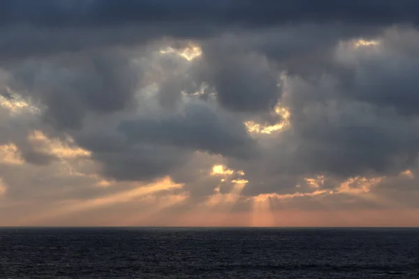 Paisaje marino al atardecer con rayos de luz a través de nubes —  Fotos de Stock