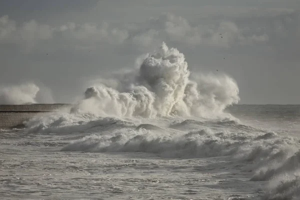 Stormachtige golven tegen de muur van de haven — Stockfoto