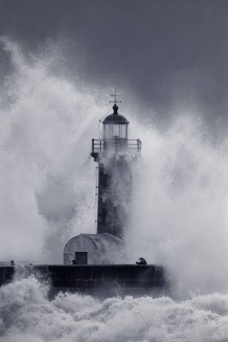 Fırtınanın ortasında dikkatsiz insanlar. Douro Nehri Ağzı eski deniz feneri, Porto, Portekiz. Siyah ve beyaza dönüştü. Ton mavisi.
