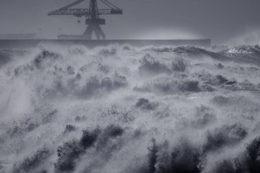 Şiddetli fırtına sırasında Leixoes 'un kuzey duvarı Portekiz' in kuzey kıyısındaki ikonik büyük vinçini görüyor..