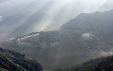 Yüksek dağlar sislerin ve güneş ışınlarının ortasında şafak söküyor. Geres Ulusal Parkı, Portekiz 'in kuzeyinde.