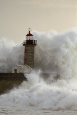 Douro Nehri 'nin ağzındaki eski deniz feneri fırtınada gün batımında.