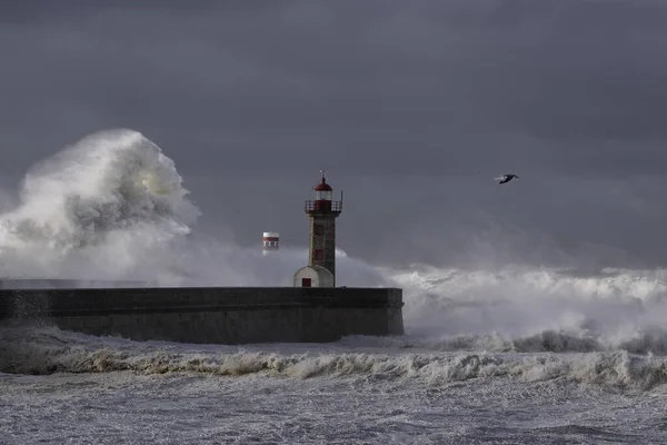 Velké Bílé Vlny Přes Mola Maják Proti Tmavé Zatažené Obloze — Stock fotografie