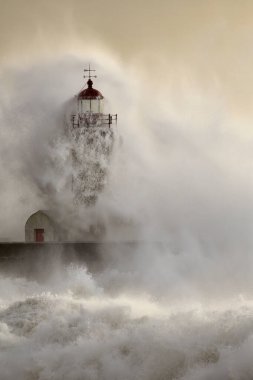 Douro Nehri 'nin ağzındaki eski deniz feneri fırtınada gün batımında.