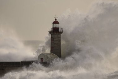 Douro Nehri 'nin ağzındaki eski deniz feneri fırtınada gün batımında.