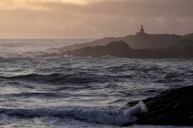Kuzey Portekiz kıyılarındaki kayalıklar sonbahar günbatımının sonlarında jeodezik bir dönüm noktası görüyorlar.