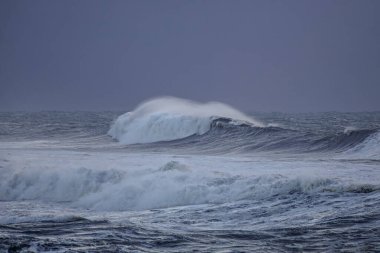 Alacakaranlıkta rüzgarla dalgalanan uzun deniz dalgaları