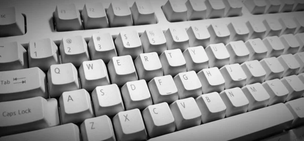 White Computer keyboard in blue light.