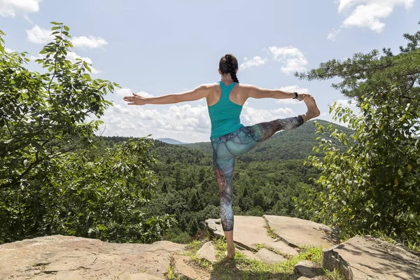 Young girl meditating with yoga on a mountain cliff