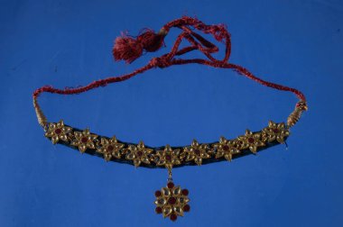 Güzel antik Hint kolyesi mavi arka planda elmas ve taşla izole edilmiş.