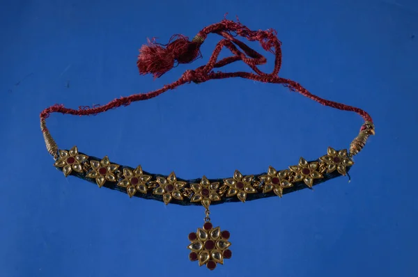 Güzel antik Hint kolyesi mavi arka planda elmas ve taşla izole edilmiş.