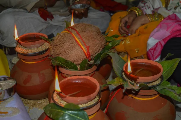 Глиняный горшок с кокосом, листьями манго, маслом, рисом, пшеницей светится для поклонения индийскому богу. — стоковое фото