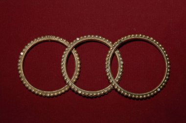 Güzel eller için kırmızı arka planda izole edilmiş el yapımı bir Hint bileziği.