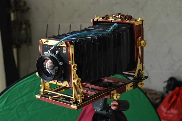 Uzman bir tekniker, antika, retro kamera 4 X 5 klasik, tripodda izole görünüyor.
