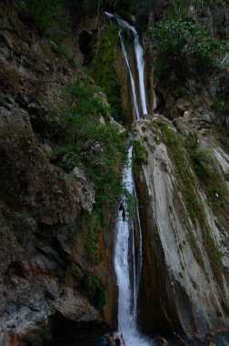 Ünlü Neer Garh Şelalesi, Rishikesh, Uttarakhand, Hindistan 'ın altında eğlenen bir grup insan.