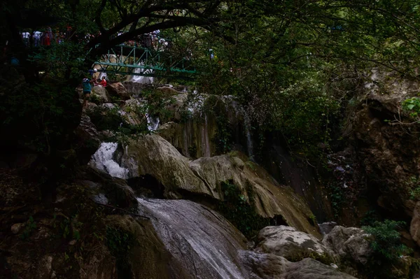 Ünlü Neer Garh Şelalesi, Rishikesh, Uttarakhand, Hindistan 'ın altında eğlenen bir grup insan.