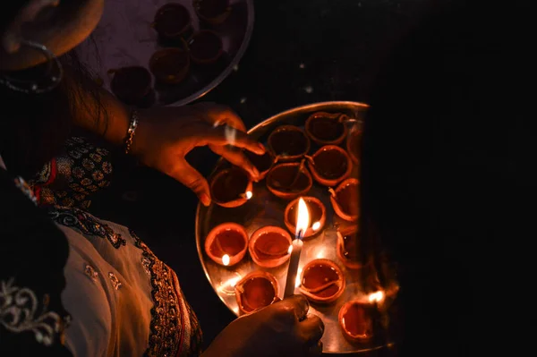 Hintli bir kadın aralık yaktı. Hindistan festivali diwali deep awali 'nin gül ve mumlarıyla dolu. Masada ateş izole edilmiş.