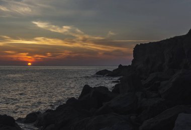 Kayalık sahilde deniz gün batımı